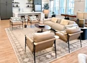 Thumbnail 16 of 28 - A living room with a beige sofa and a black and white rug.