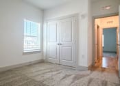 Thumbnail 6 of 28 - A room with a white door and a window with blinds.