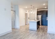 Thumbnail 27 of 28 - A kitchen with a refrigerator, sink, and cabinets.