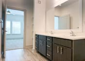 Thumbnail 24 of 28 - A bathroom with a sink, mirror, and cabinets.