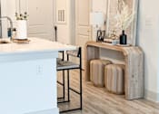 Thumbnail 25 of 28 - A white kitchen with a wooden island and a bench.