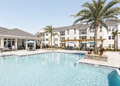 Thumbnail 1 of 22 - A large swimming pool in front of a resort.
