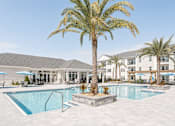 Thumbnail 3 of 22 - A palm tree stands in the middle of a pool.