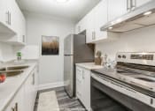 Thumbnail 13 of 16 - Kitchen with white cabinets and stainless steel appliances at Platts Crossing, Ontario, N6H 4P4