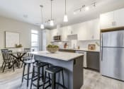 Thumbnail 14 of 28 - Open kitchen and dining area with stainless steel appliances and bar stools  at 101 Base Line Road West, London