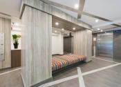 Thumbnail 2 of 19 - a bench in the lobby of a building with an elevator in the background