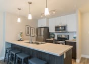 Thumbnail 16 of 19 - a kitchen with a large island and stainless steel appliances
