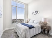 Thumbnail 27 of 37 - A bedroom with a large bed and a view of the city.