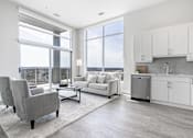 Thumbnail 21 of 37 - A modern living room with a grey sofa and a grey armchair.