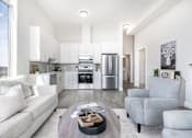 Thumbnail 16 of 37 - A modern kitchen with white cabinets and stainless steel appliances.