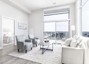 Thumbnail 19 of 37 - A living room with a large window and a view of the city.
