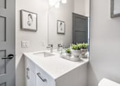Thumbnail 33 of 37 - A bathroom with a white sink and a mirror.