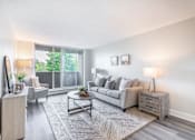 Thumbnail 11 of 15 - A living room with a grey couch, a coffee table, and a lamp  at Platts Crossing, London, ON, N6H 4P4