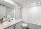 Thumbnail 15 of 15 - A white bathroom with a sink, toilet, and bathtub  at Platts Crossing, London, ON, N6H 4P4