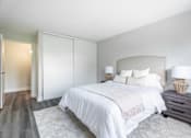 Thumbnail 12 of 15 - A bedroom with a large bed and a nightstand with a lamp  at Platts Crossing, London, ON, N6H 4P4