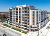 Thumbnail 4 of 37 - A large multi-story building with orange and white balconies.
