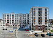 Thumbnail 5 of 37 - A large building with a parking lot in front of it.