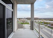 Thumbnail 35 of 37 - A view from a window looking out at a highway and a distant cityscape.