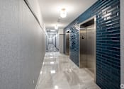 Thumbnail 7 of 37 - A long hallway with a series of elevators on the right.