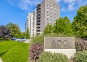 Thumbnail 17 of 23 - a large stone sign with the number 60 on it in front of an apartment building