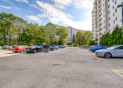 Thumbnail 22 of 23 - a parking lot with cars parked in front of an apartment building