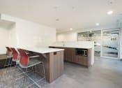 Thumbnail 6 of 19 - resident lounge white countertops and a wooden island with three red chairs