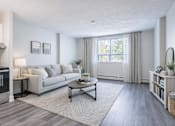 Thumbnail 9 of 10 - A modern living room with a grey couch, a coffee table, and a large window with curtains.