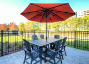 Thumbnail 9 of 19 - a patio with a table and chairs and an umbrella