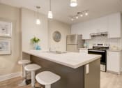 Thumbnail 4 of 11 - Kitchen with white cabinets and an island.