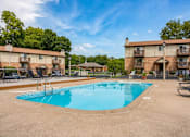 Thumbnail 5 of 6 - A swimming pool in a residential area surrounded by apartment buildings.