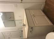 Thumbnail 24 of 51 - A white toilet is in a small bathroom with a cabinet and a mirror.