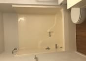 Thumbnail 25 of 51 - A white bathroom with a white tub and a white toilet.