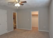 Thumbnail 37 of 51 - A room with a ceiling fan and carpeted floor.