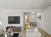 Thumbnail 10 of 48 - a living room with a large tv on the wall and a dining room table in the background