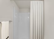 Thumbnail 28 of 43 - a bathroom with a shower and a white shower curtain