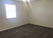 Thumbnail 22 of 51 - A room with a carpeted floor and a window letting in sunlight.