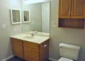 Thumbnail 43 of 51 - A bathroom with a white toilet and a wooden vanity.