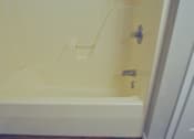 Thumbnail 44 of 51 - A white bathtub with a silver faucet and handle.