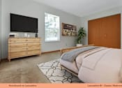 Thumbnail 9 of 24 - A bedroom with a bed, dresser, and a television.