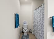 Thumbnail 56 of 67 - a bathroom with a toilet and a shower curtain