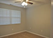 Thumbnail 40 of 51 - A room with a ceiling fan and a window with blinds.