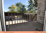 Thumbnail 7 of 24 - A balcony with a brick wall and a metal railing.