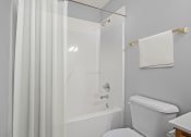 Thumbnail 45 of 48 - a bathroom with a white tub and a white shower curtain