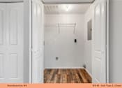 Thumbnail 33 of 35 - A white closet with a wooden floor and a white door.