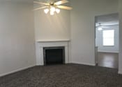 Thumbnail 17 of 51 - A room with a fireplace and a ceiling fan.