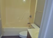 Thumbnail 46 of 51 - A white toilet sits next to a bathtub in a bathroom.