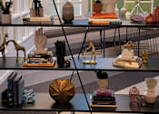 Thumbnail 2 of 10 - a glass wall with various sculptures on it and a staircase in the background