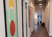 Thumbnail 3 of 10 - a view of the gallery space with paintings on the floor and a staircase in the background