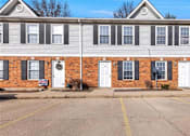 Thumbnail 3 of 35 - A building with a red brick wall and white doors.