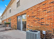 Thumbnail 1 of 35 - A brick wall with a sliding glass door and a wall-mounted air conditioning unit.